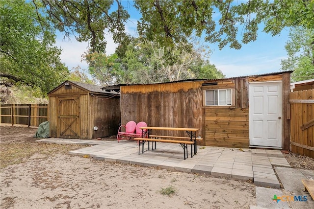 exterior space featuring a storage unit, a fenced backyard, and an outbuilding