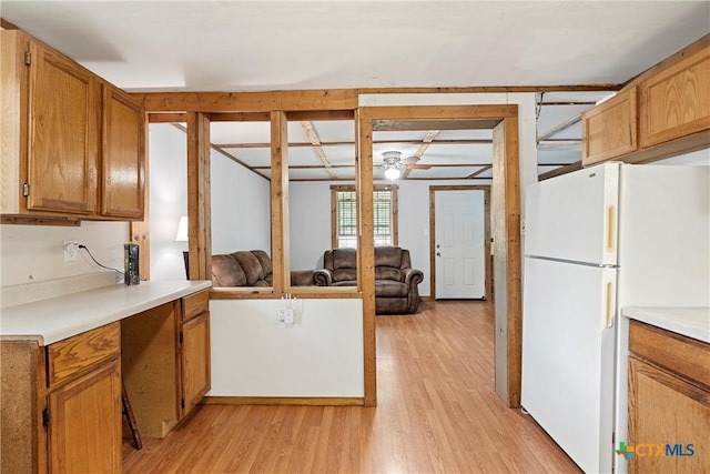 kitchen featuring freestanding refrigerator, light wood finished floors, and light countertops
