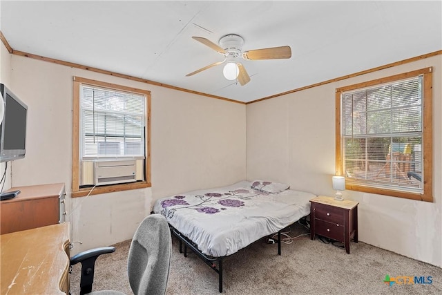 carpeted bedroom with ceiling fan and ornamental molding