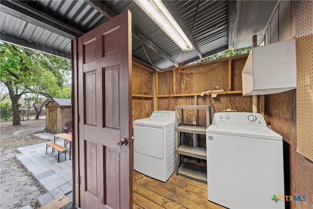 clothes washing area with laundry area, independent washer and dryer, and hardwood / wood-style floors