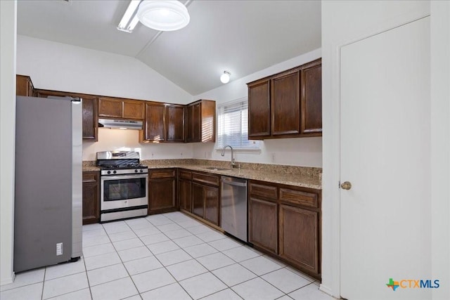 kitchen featuring light stone countertops, lofted ceiling, a sink, under cabinet range hood, and appliances with stainless steel finishes