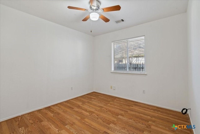 unfurnished room with a ceiling fan, visible vents, and light wood-type flooring