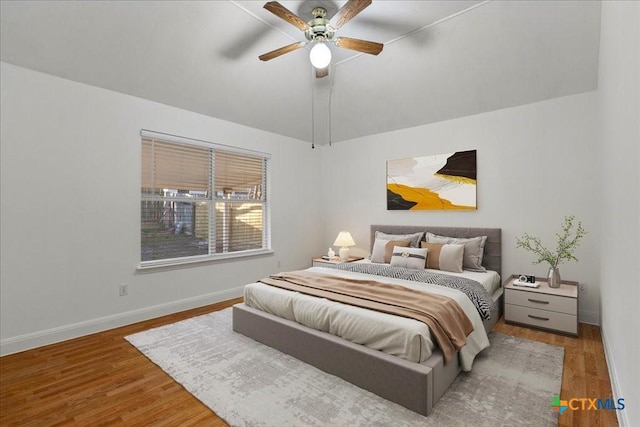 bedroom featuring baseboards, wood finished floors, a ceiling fan, and vaulted ceiling