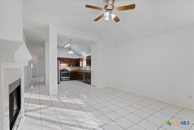 unfurnished living room featuring vaulted ceiling, light tile patterned floors, a fireplace, and ceiling fan