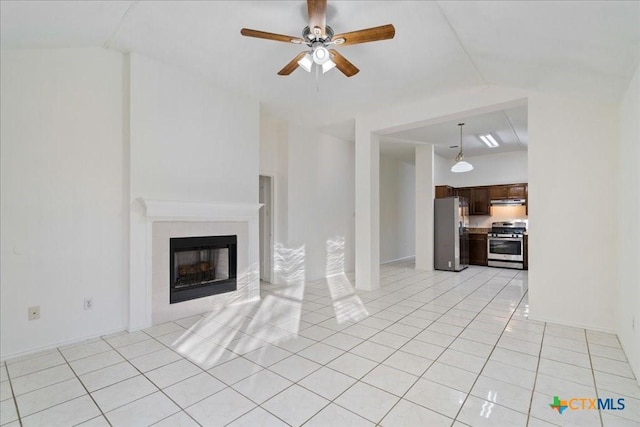 unfurnished living room with light tile patterned floors, ceiling fan, a fireplace, and vaulted ceiling