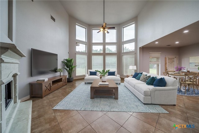 934 Wilderness Trl, New Braunfels, TX 78132 - tiled living area with a towering ceiling, plenty of natural light, a ceiling fan, a high end fireplace, and recessed lighting