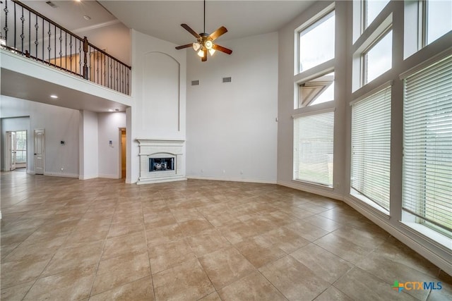 934 Wilderness Trl, New Braunfels, TX 78132 - unfurnished living room featuring a high ceiling, ceiling fan, baseboards, light tile patterned floors, and a fireplace