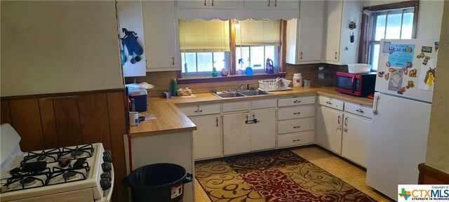 kitchen featuring white appliances, white cabinets, and sink