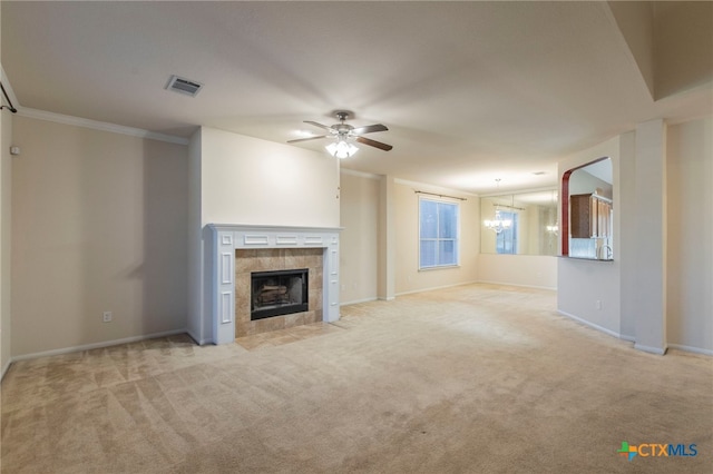 612 Weeping Willow Dr, Temple, TX 76502 - unfurnished living room featuring light carpet, a ceiling fan, a tiled fireplace, ornamental molding, and a chandelier