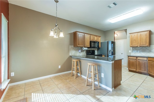 612 Weeping Willow Dr, Temple, TX 76502 - kitchen with black microwave, electric range, tasteful backsplash, stainless steel refrigerator with ice dispenser, and light tile patterned floors