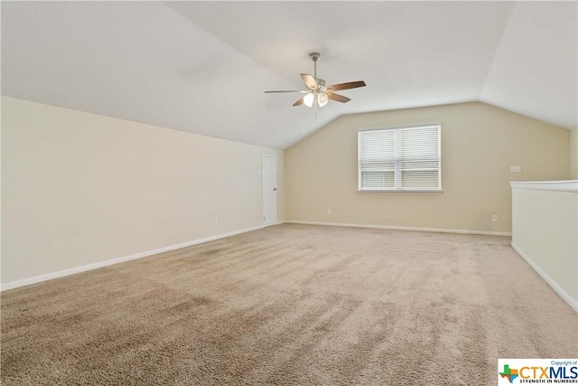additional living space featuring a ceiling fan, carpet floors, vaulted ceiling, and baseboards