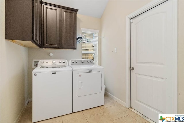 laundry area with cabinet space, washing machine and dryer, baseboards, and light tile patterned floors