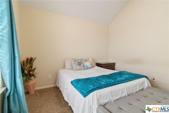 carpeted bedroom with lofted ceiling and baseboards