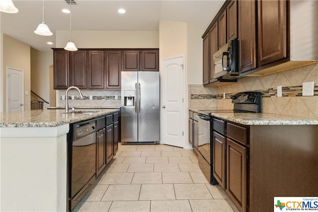 kitchen featuring backsplash, black appliances, sink, decorative light fixtures, and light stone counters