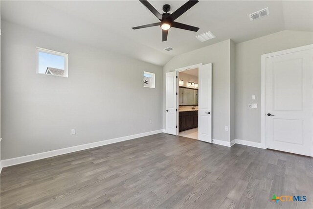 264 Sweeping Sage Ln, San Marcos, TX 78666 - unfurnished bedroom with lofted ceiling, wood finished floors, baseboards, connected bathroom, and a ceiling fan