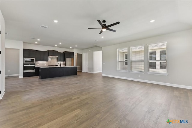 264 Sweeping Sage Ln, San Marcos, TX 78666 - unfurnished living room with a ceiling fan, baseboards, wood finished floors, and recessed lighting
