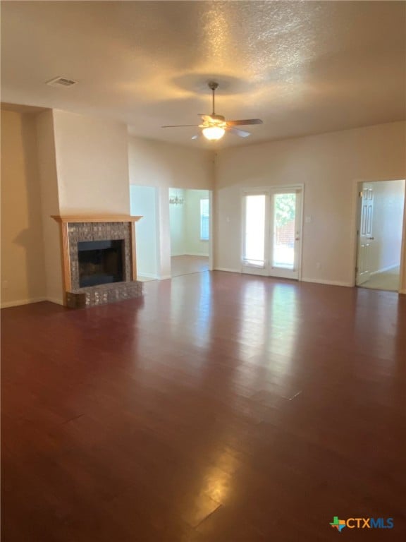 unfurnished living room with a textured ceiling, a fireplace, hardwood / wood-style flooring, and ceiling fan