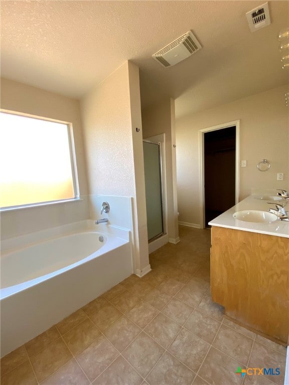 bathroom featuring vanity, shower with separate bathtub, a textured ceiling, and tile patterned flooring