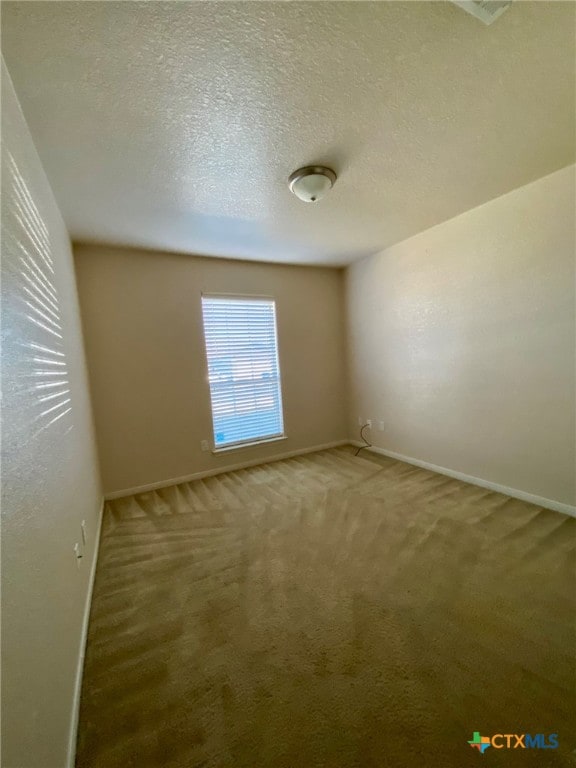 carpeted spare room with a textured ceiling