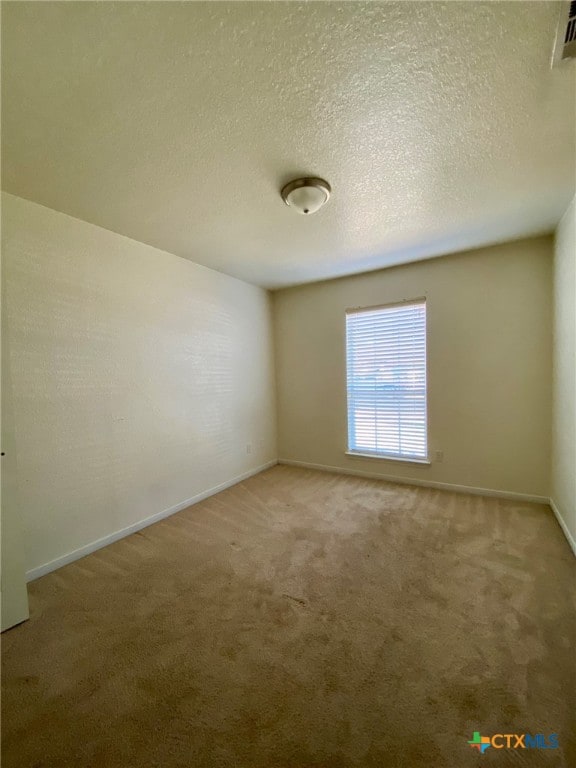 carpeted spare room with a textured ceiling