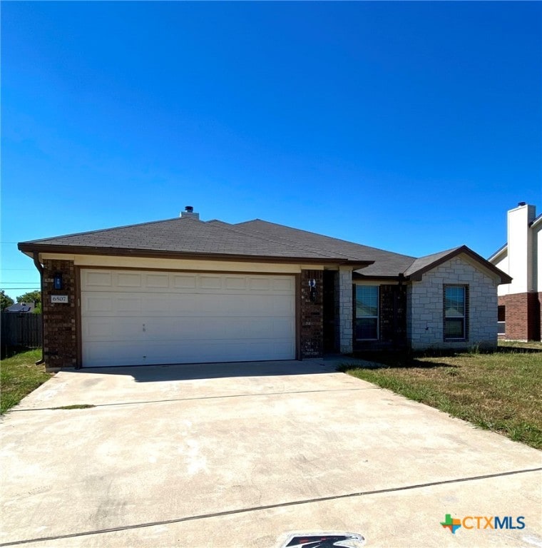 single story home featuring a garage and a front yard