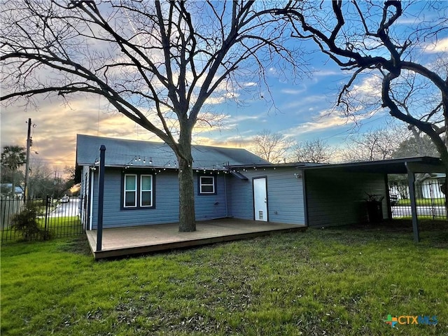 view of front of home featuring a yard, a carport, fence, and a wooden deck