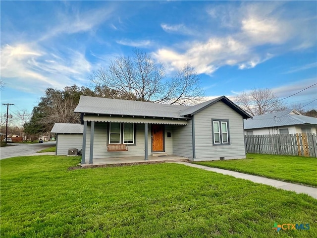 view of front of property with central AC unit, a porch, a front yard, and fence