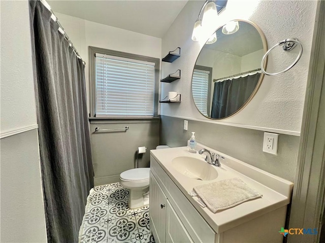 bathroom with baseboards, a shower with shower curtain, toilet, tile patterned flooring, and vanity