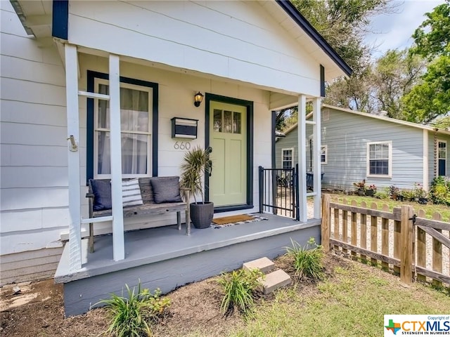 view of exterior entry featuring covered porch