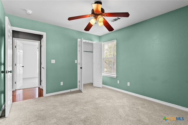 unfurnished bedroom featuring visible vents, baseboards, a ceiling fan, a closet, and carpet floors