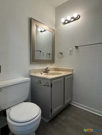 bathroom featuring vanity, hardwood / wood-style flooring, and toilet