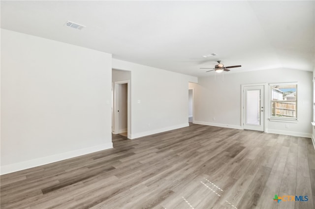 unfurnished living room with ceiling fan, lofted ceiling, and light wood-type flooring