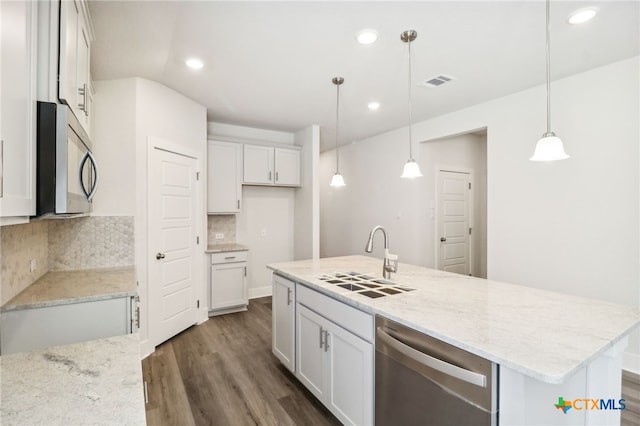 kitchen featuring dark wood-type flooring, a center island with sink, sink, hanging light fixtures, and white cabinetry