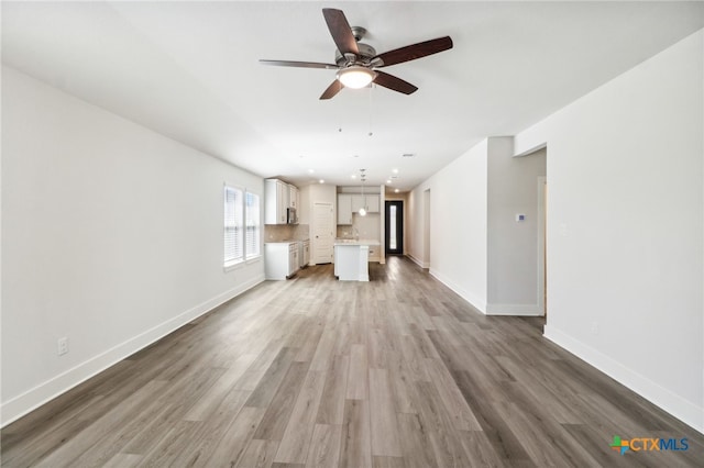 unfurnished living room with wood-type flooring and ceiling fan