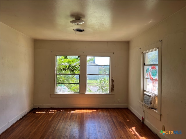 spare room with plenty of natural light, dark wood-type flooring, and cooling unit