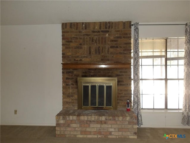 room details featuring a brick fireplace and a fire extinguisher