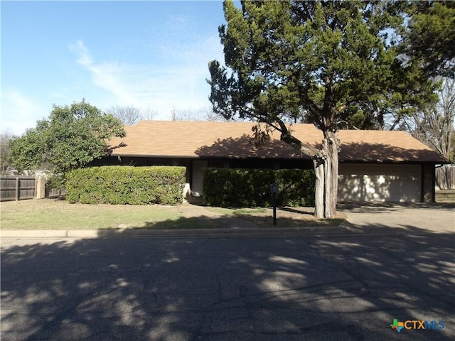 view of front of home featuring a garage and fence