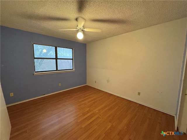 unfurnished room featuring a textured ceiling, wood finished floors, a ceiling fan, and baseboards