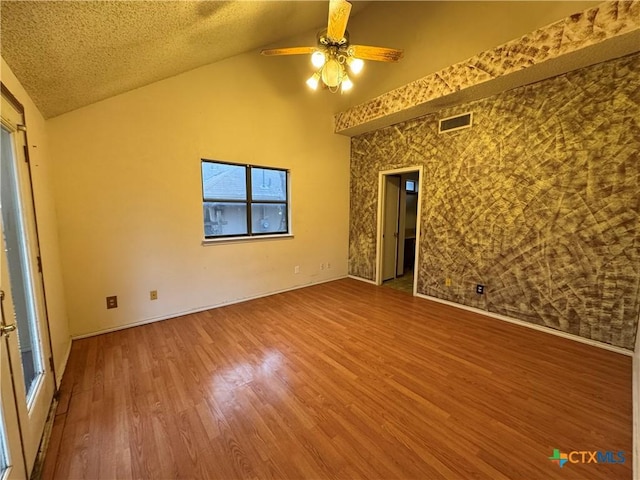 unfurnished room with visible vents, ceiling fan, a textured ceiling, and wood finished floors