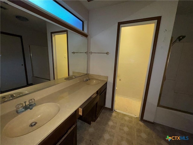 bathroom with shower / bath combination, a sink, and double vanity