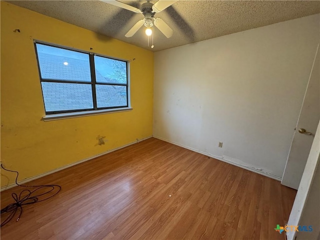 unfurnished room with a textured ceiling, ceiling fan, and wood finished floors