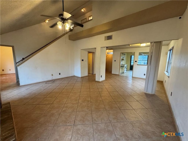 unfurnished living room with visible vents, vaulted ceiling, ceiling fan, tile patterned flooring, and baseboards