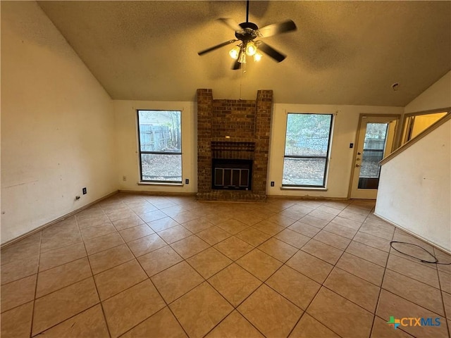 unfurnished living room with a healthy amount of sunlight, a brick fireplace, vaulted ceiling, and a ceiling fan