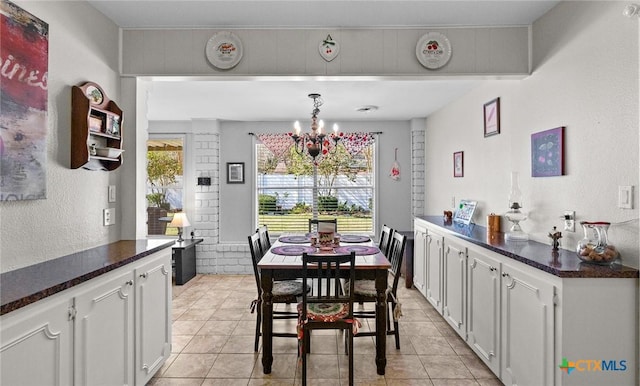 dining room featuring plenty of natural light, light tile patterned flooring, and a chandelier