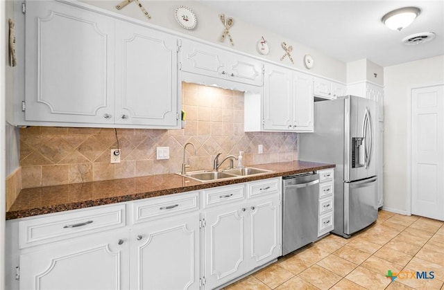 kitchen featuring visible vents, white cabinetry, a sink, appliances with stainless steel finishes, and backsplash