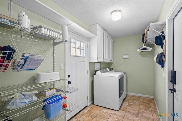 washroom featuring baseboards, a textured ceiling, cabinet space, and washer and dryer