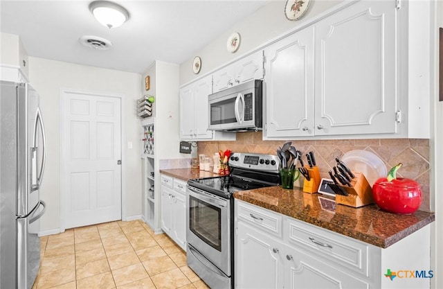 kitchen featuring visible vents, dark stone counters, white cabinets, backsplash, and stainless steel appliances