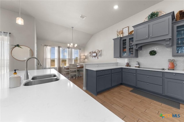 kitchen with hanging light fixtures, gray cabinets, and sink