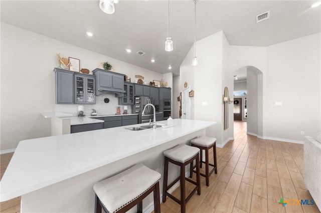 kitchen featuring appliances with stainless steel finishes, pendant lighting, sink, a breakfast bar area, and a large island