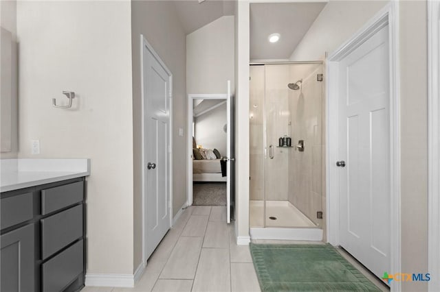 bathroom featuring vanity, a shower with shower door, and tile patterned flooring